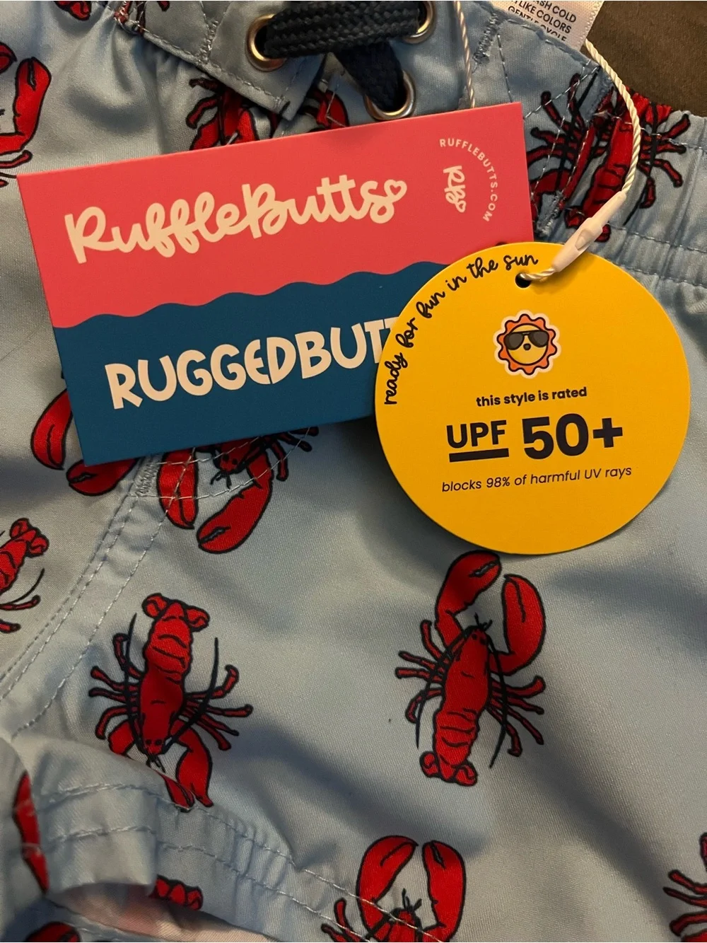RuffleButts Light Blue Swim Trunks with Red Lobster Print